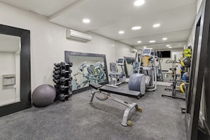 A gym with exercise equipment, a large mirror, and a ball. - City Express by Marriott Mountain View/Sunnyvale (Mountain View)