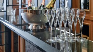 A bar area with a metal bar counter, a large bowl of champagne, and several empty wine glasses lined up. - Maison Astor Paris, Curio Collection by Hilton (Paris)