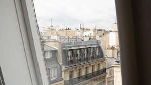 A skylight window with a view of Parisian buildings. - Hôtel Petit Lafayette (Paris)