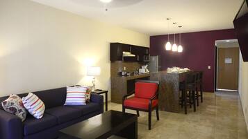 Una sala de estar moderna con un sofá, una mesa de centro y una zona de comedor con barra.