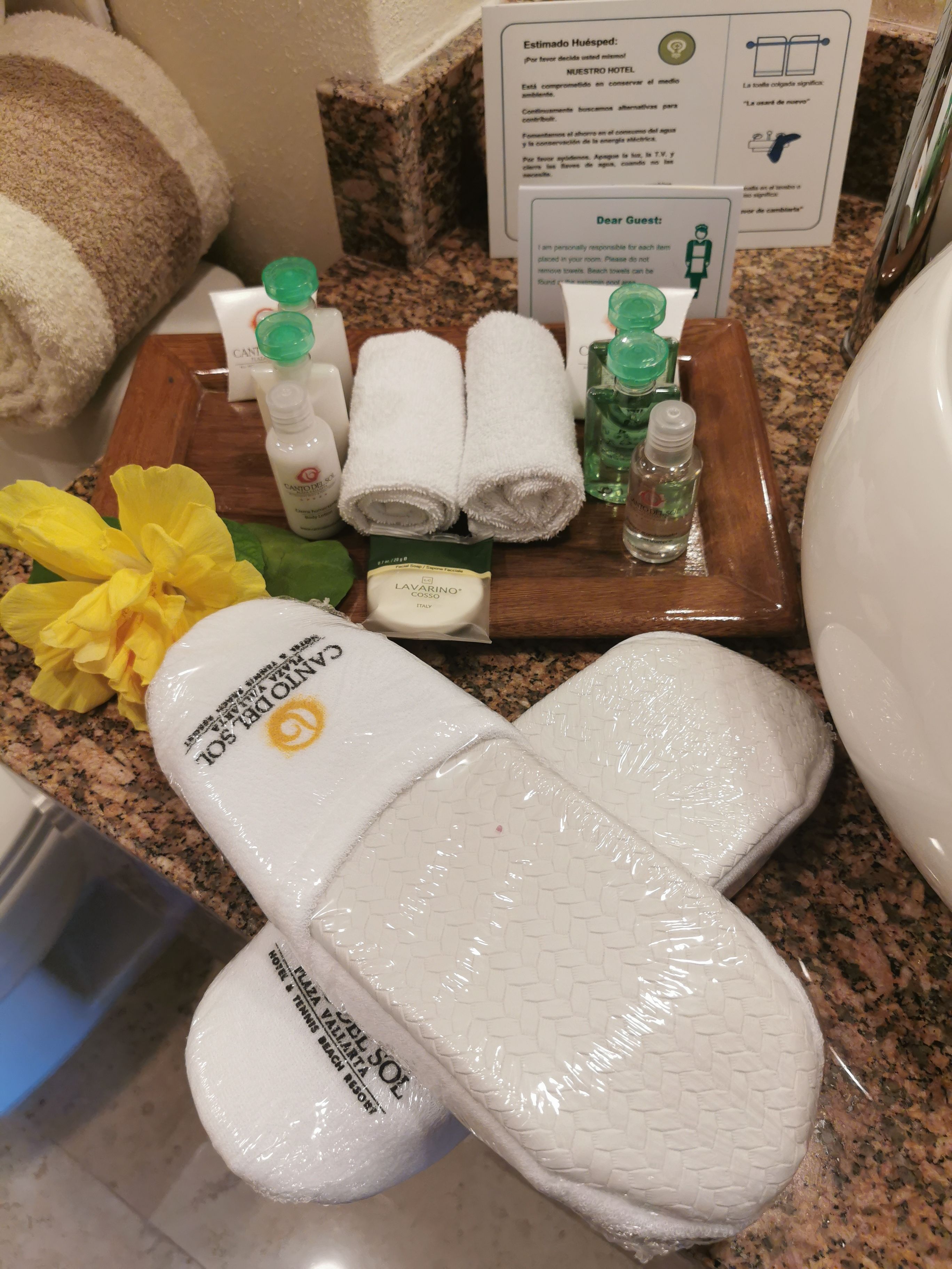 Une salle de bain d’hôtel équipée de produits de toilette, de serviettes et d’une pancarte.