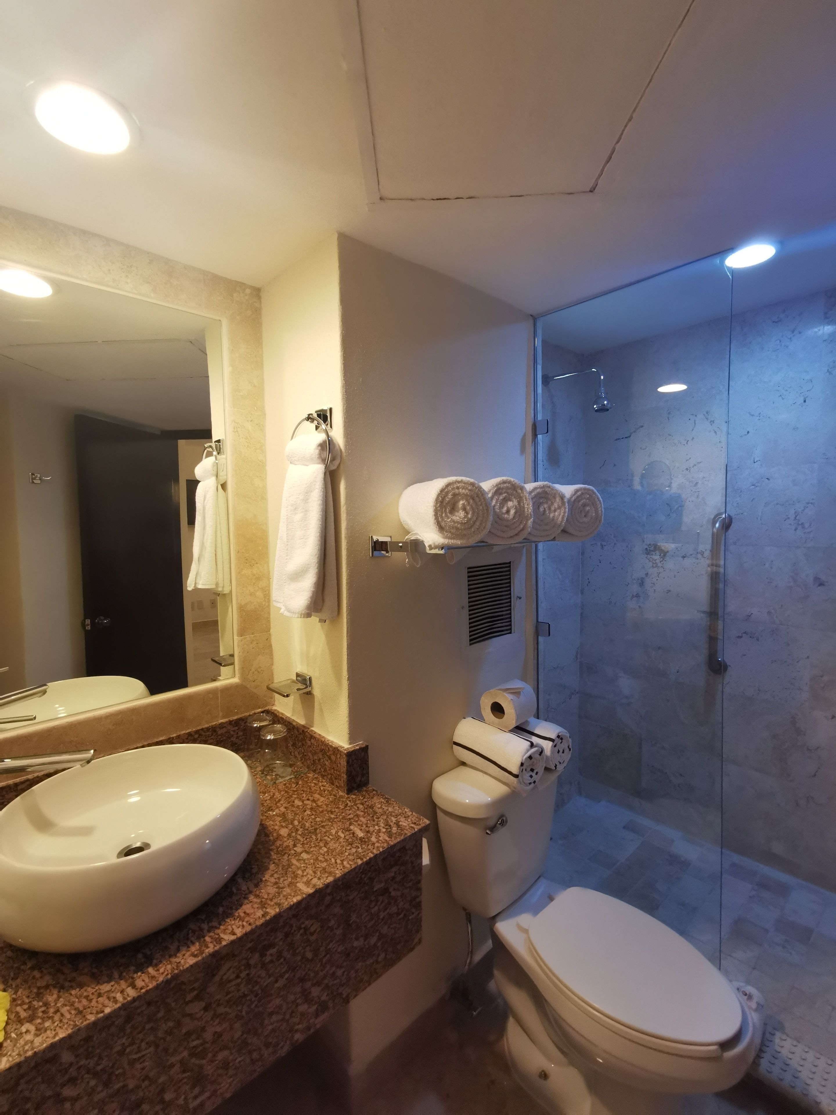 A bathroom with a sink, toilet, and a glass-enclosed shower.