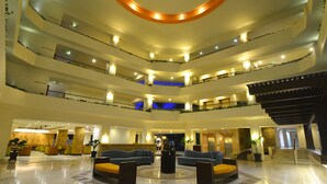 A multi-level hotel lobby with a central seating area, multiple balconies, and a modern design. - Canto del Sol Puerto Vallarta All Inclusive (Puerto Vallarta)