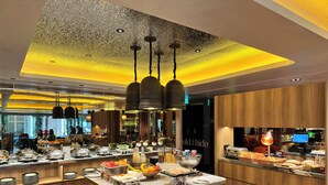 Un restaurante moderno con un montaje tipo bufé, paneles de madera e iluminación contemporánea.