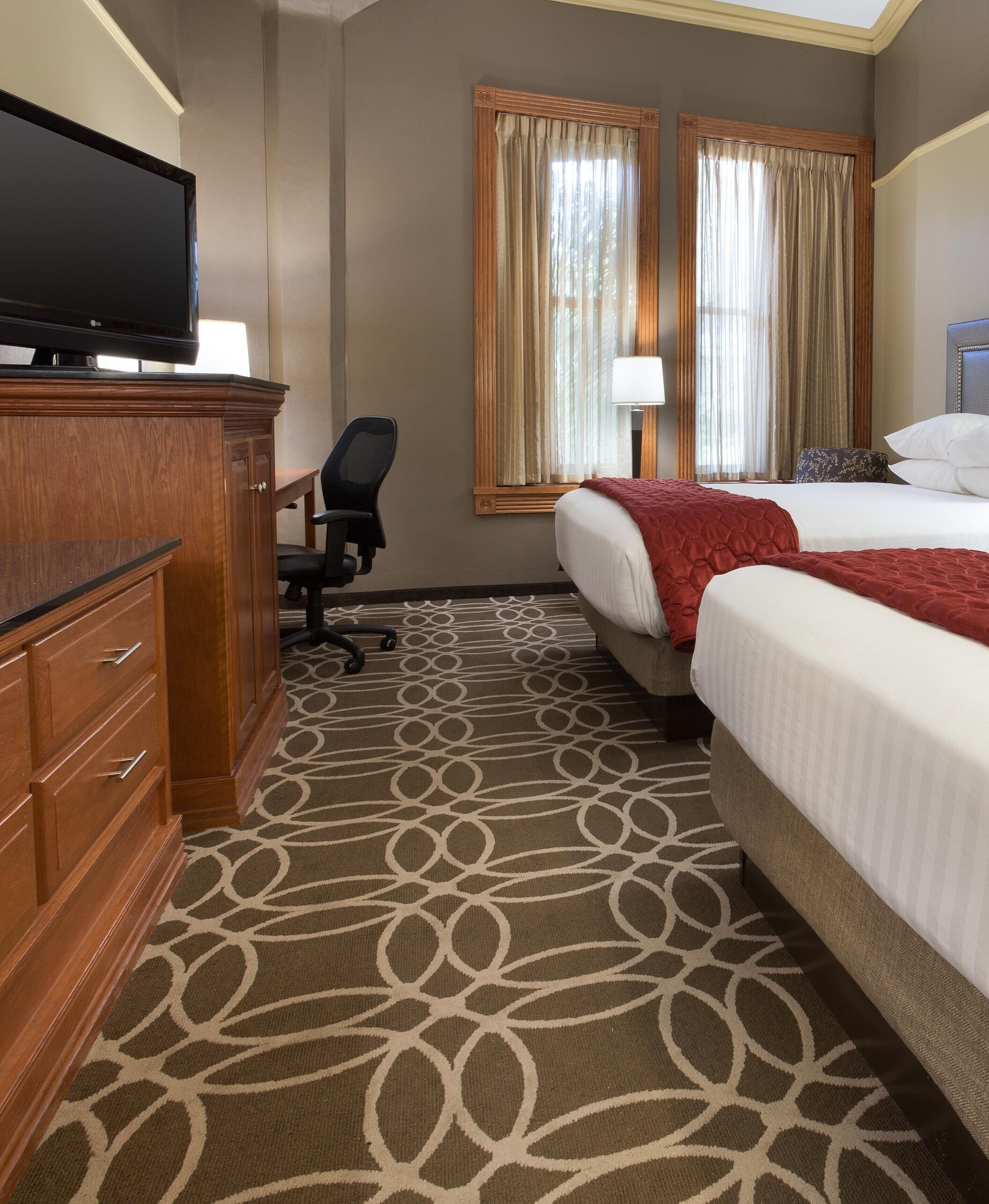 Une chambre d’hôtel équipée d’un lit, d’un bureau, d’une chaise et d’un téléviseur.