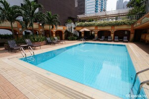 Una piscina al aire libre, sillones reclinables de piscina