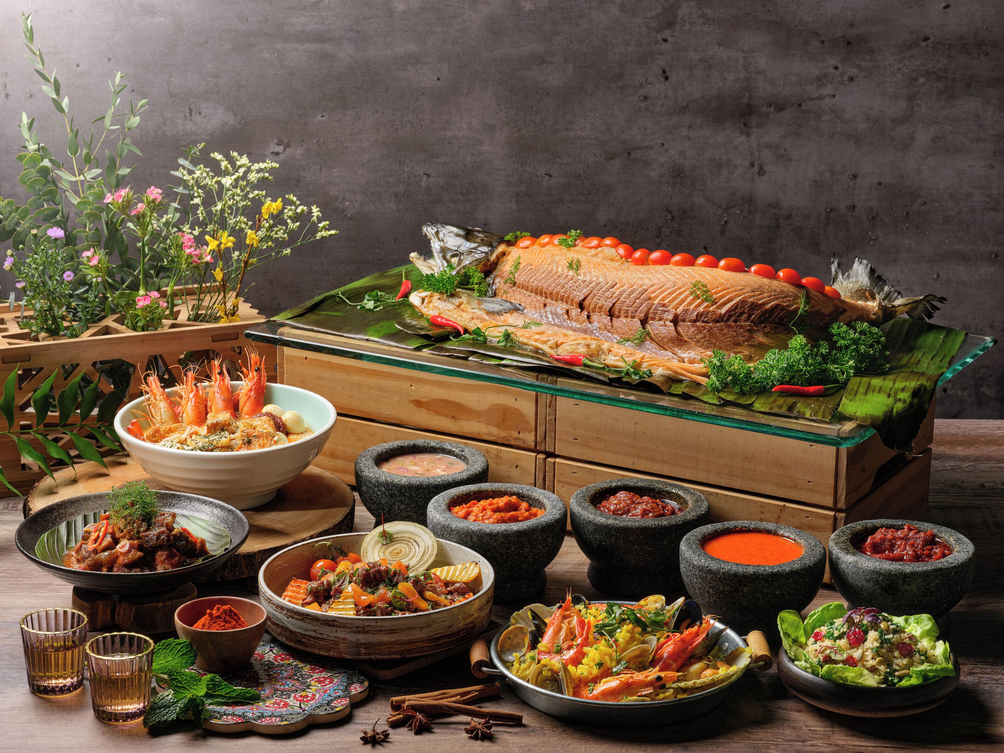 Ein reichhaltiges Meeresfrüchtebuffet mit einem großen Fisch als Mittelstück, verschiedenen Gerichten und traditionellem Geschirr.