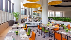 A modern restaurant with high ceilings, large windows, and a central bar area. - Holiday Inn Singapore Atrium by IHG (Singapore)