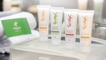 Uma bandeja com diversos produtos de cuidados da Soak, incluindo loção corporal, sabonete líquido para mãos e corpo e shampoo para brilho do cabelo.