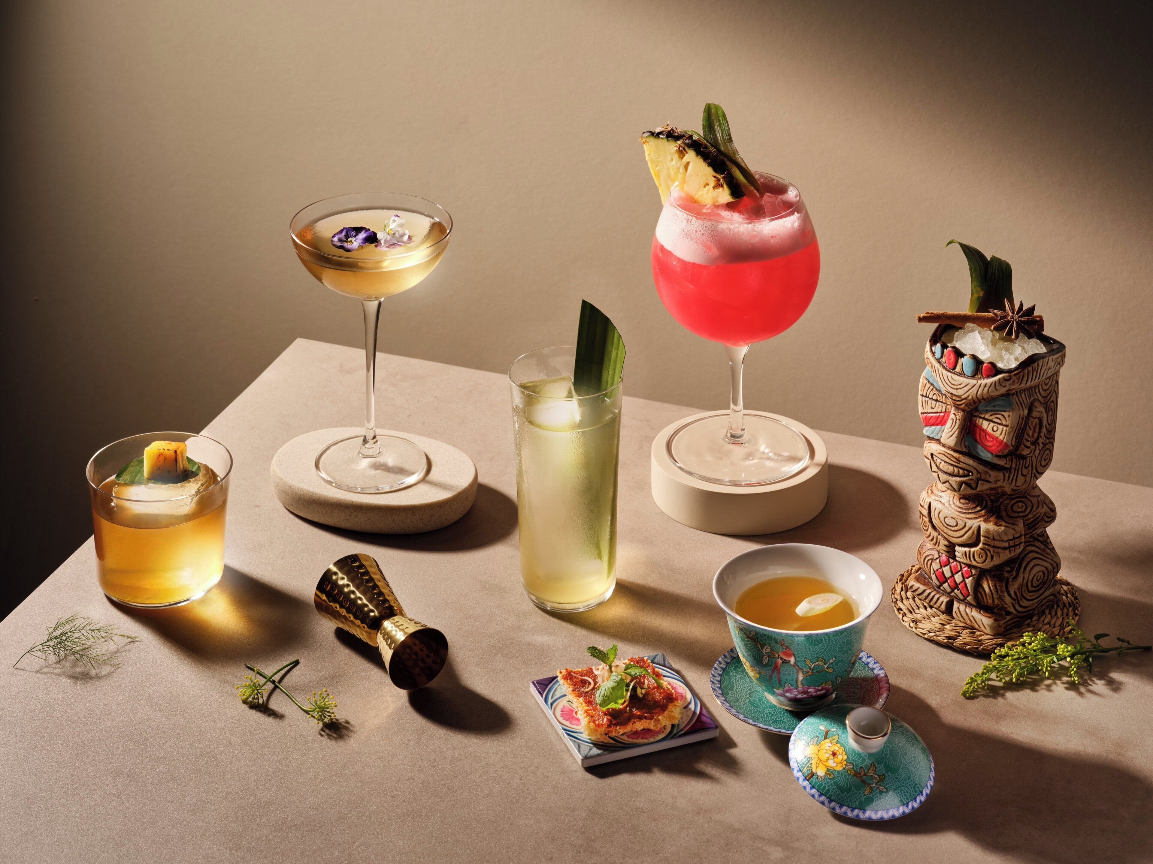 A variety of drinks and a decorative wooden figure on a table.