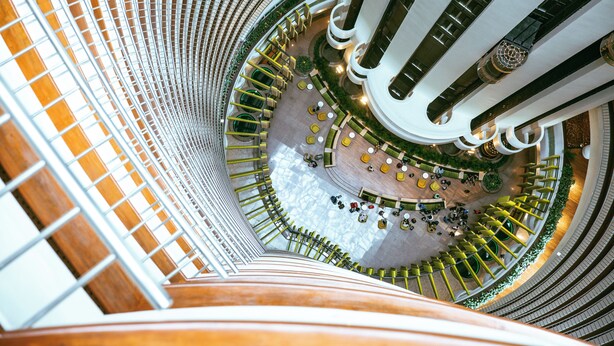 A multi-level atrium with a central open space surrounded by seating areas and staircases. - Holiday Inn Singapore Atrium by IHG (Singapore)