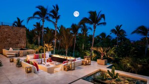 A luxurious outdoor lounge area with a fire feature, seating, and a pool. - One&Only Palmilla, Los Cabos (San José del Cabo)