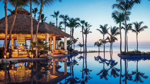 A resort with a pool, palm trees, and a thatched-roof building. - One&Only Palmilla, Los Cabos (San José del Cabo)