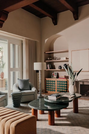 A living room with a sofa, a round coffee table, a lamp, and a bookshelf.