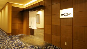 A hallway with a patterned carpet, wooden panel walls, and a sign with Japanese characters. - Sapporo Excel Hotel Tokyu (Sapporo)