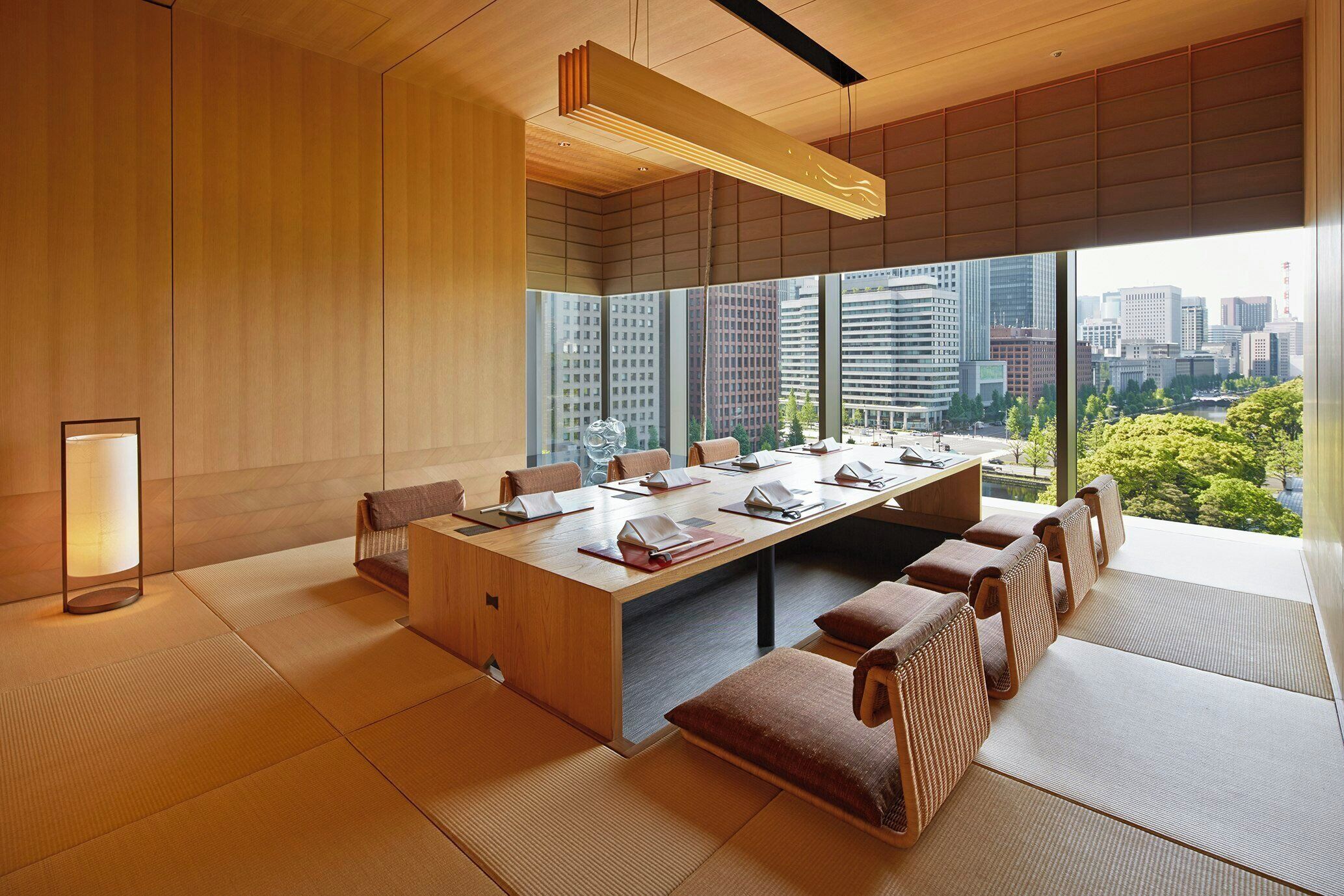 A modern meeting room with a large table, chairs, and tatami mats.