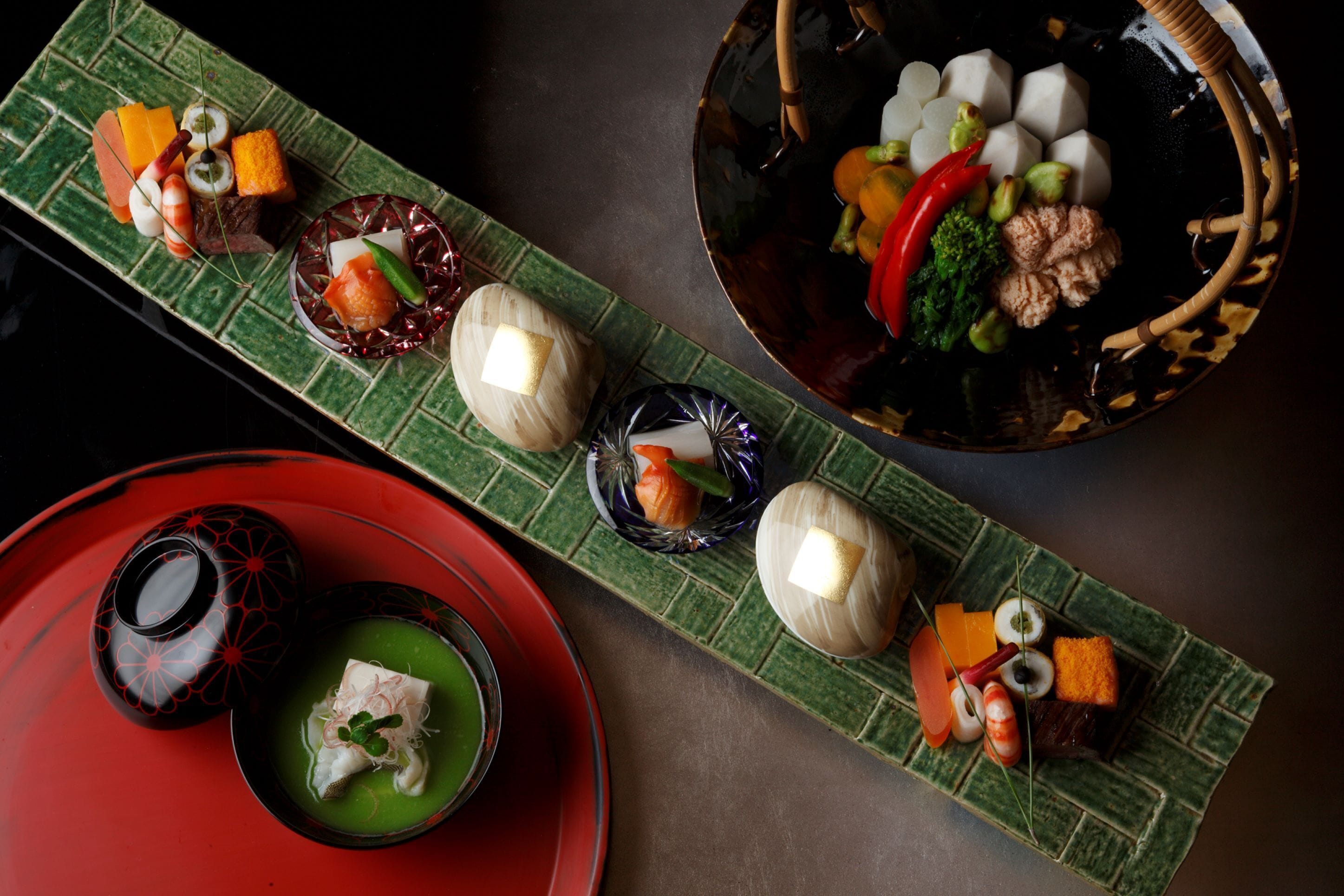 Variedad de platos japoneses dispuestos en una bandeja verde con diseño.
