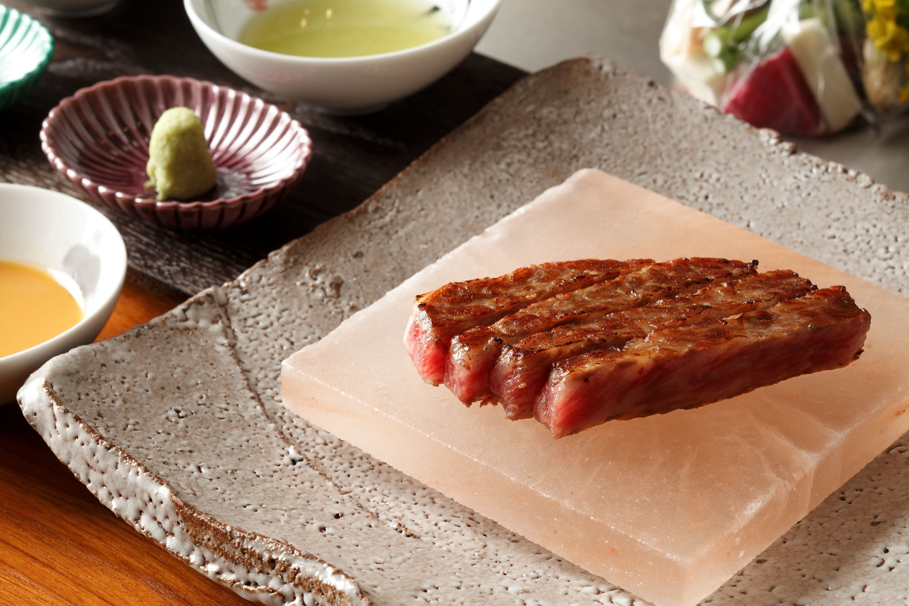 A steak on a rectangular plate with a textured background.