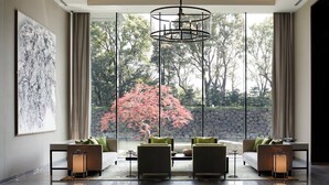 Un intérieur moderne avec une grande fenêtre, un luminaire suspendu et un ensemble de canapés.