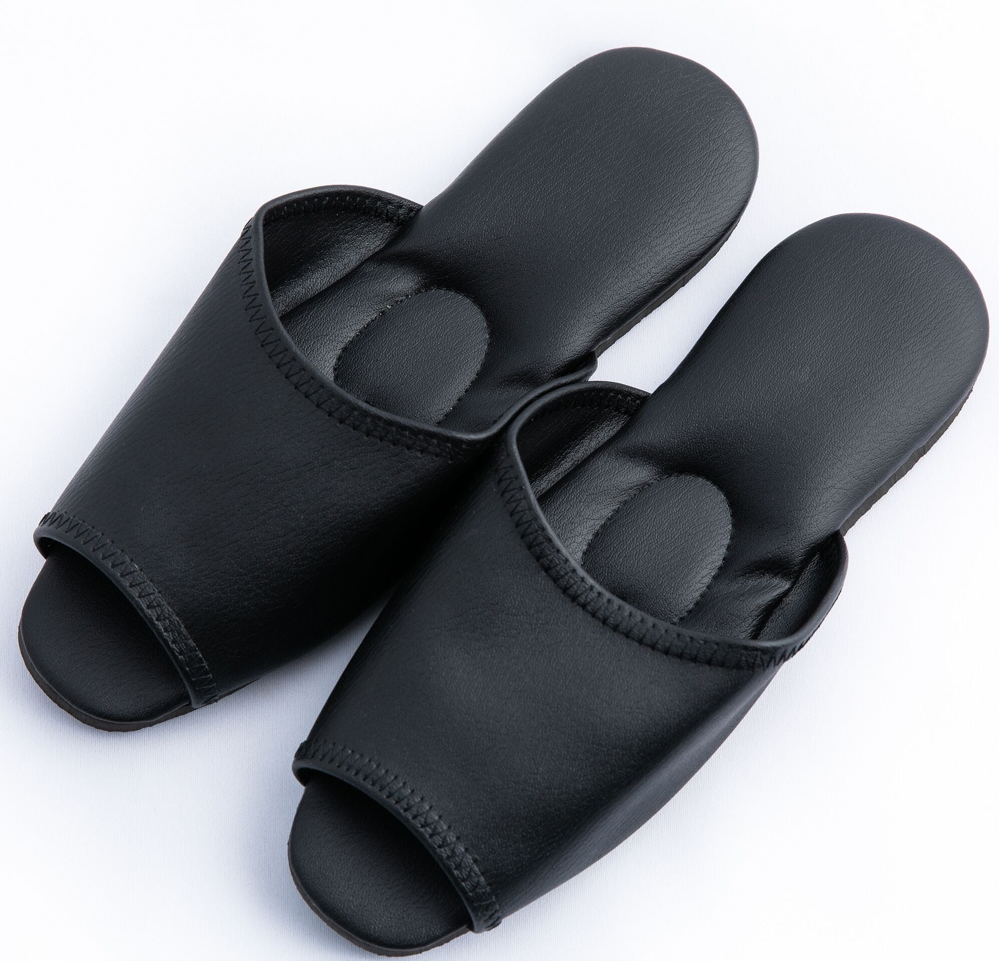 A pair of black slip-on shoes with a textured sole and a padded interior.