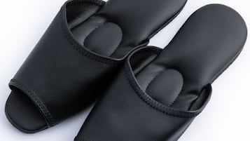 A pair of black slip-on shoes with a textured sole and a padded interior.