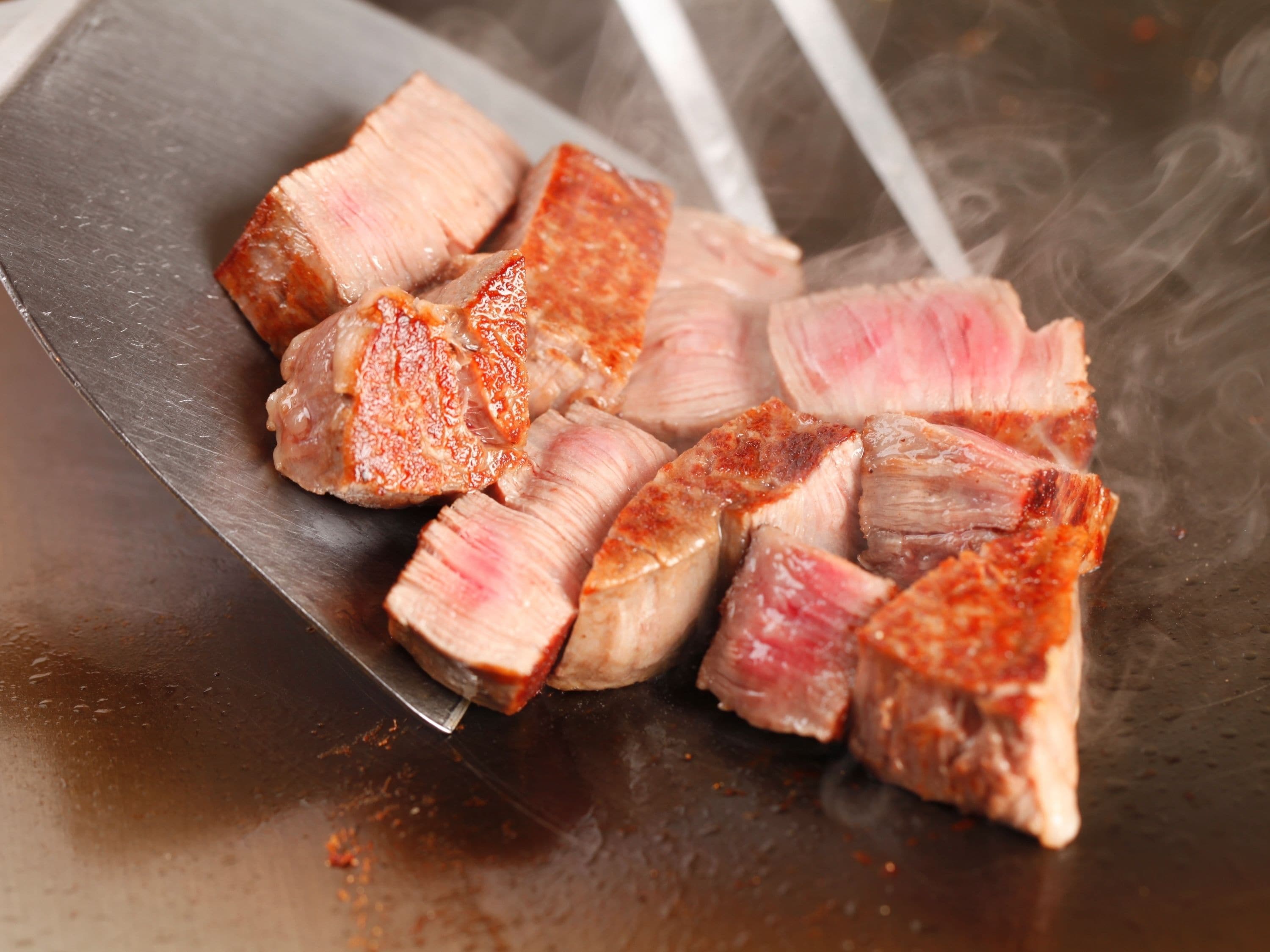A close-up of sliced meat on a metal surface.