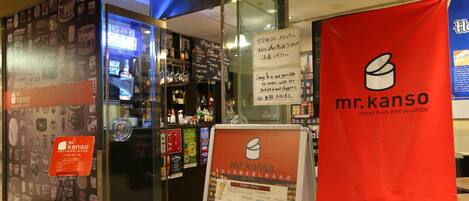 Ein Restaurantinneres mit einer Speisekarte, einem roten Banner und einer Glastheke.