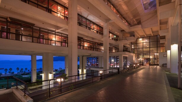 A multi-level hotel interior with balconies, large windows, and a view of the sea. - Hotel Ranpu (Hirado-shi)
