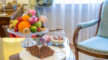 Ein Esstisch mit Obstschale, einer Glaskugel mit Joghurt und einem Teller mit Schokoladendessert.