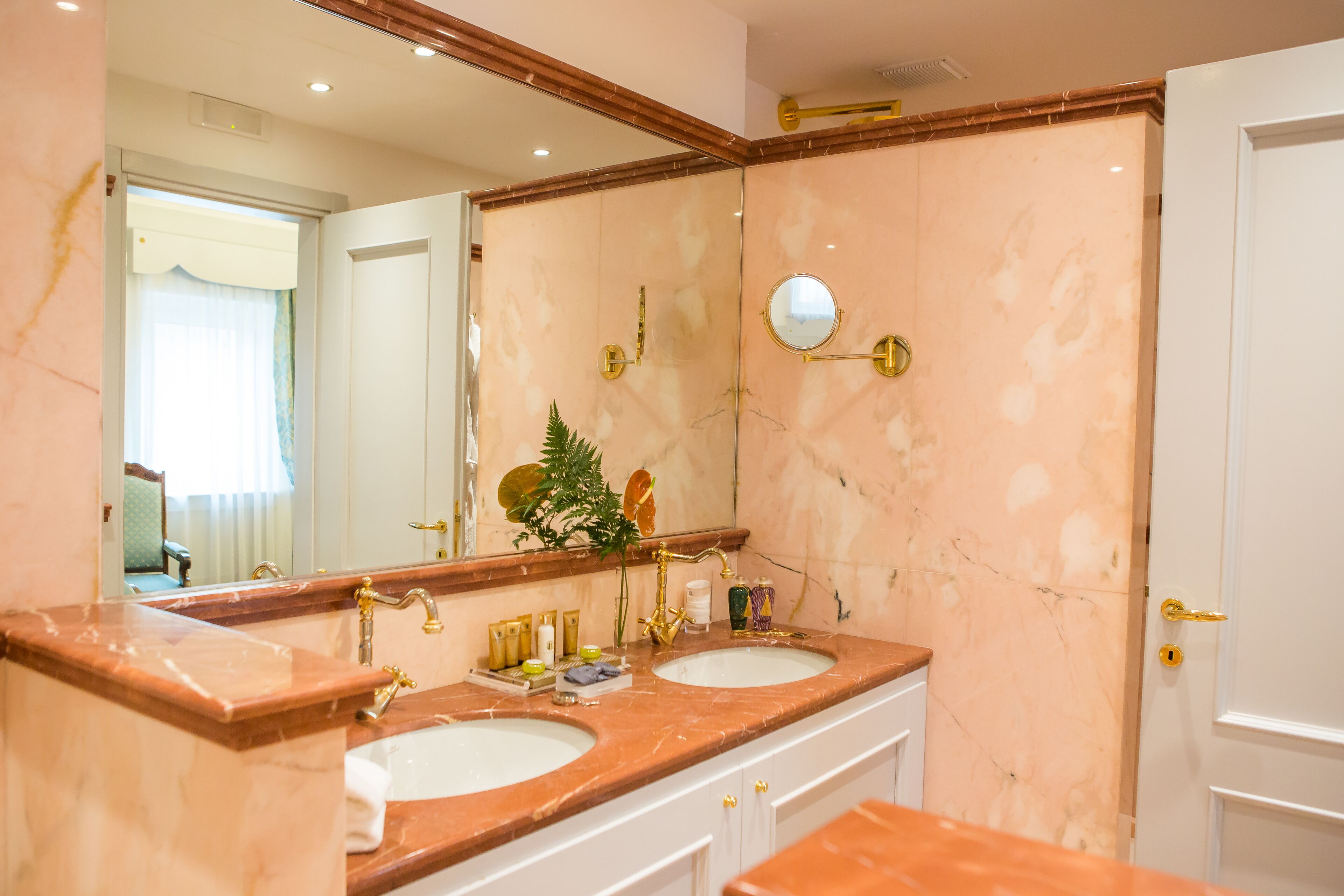 A bathroom with two sinks, a large mirror, and a door.
