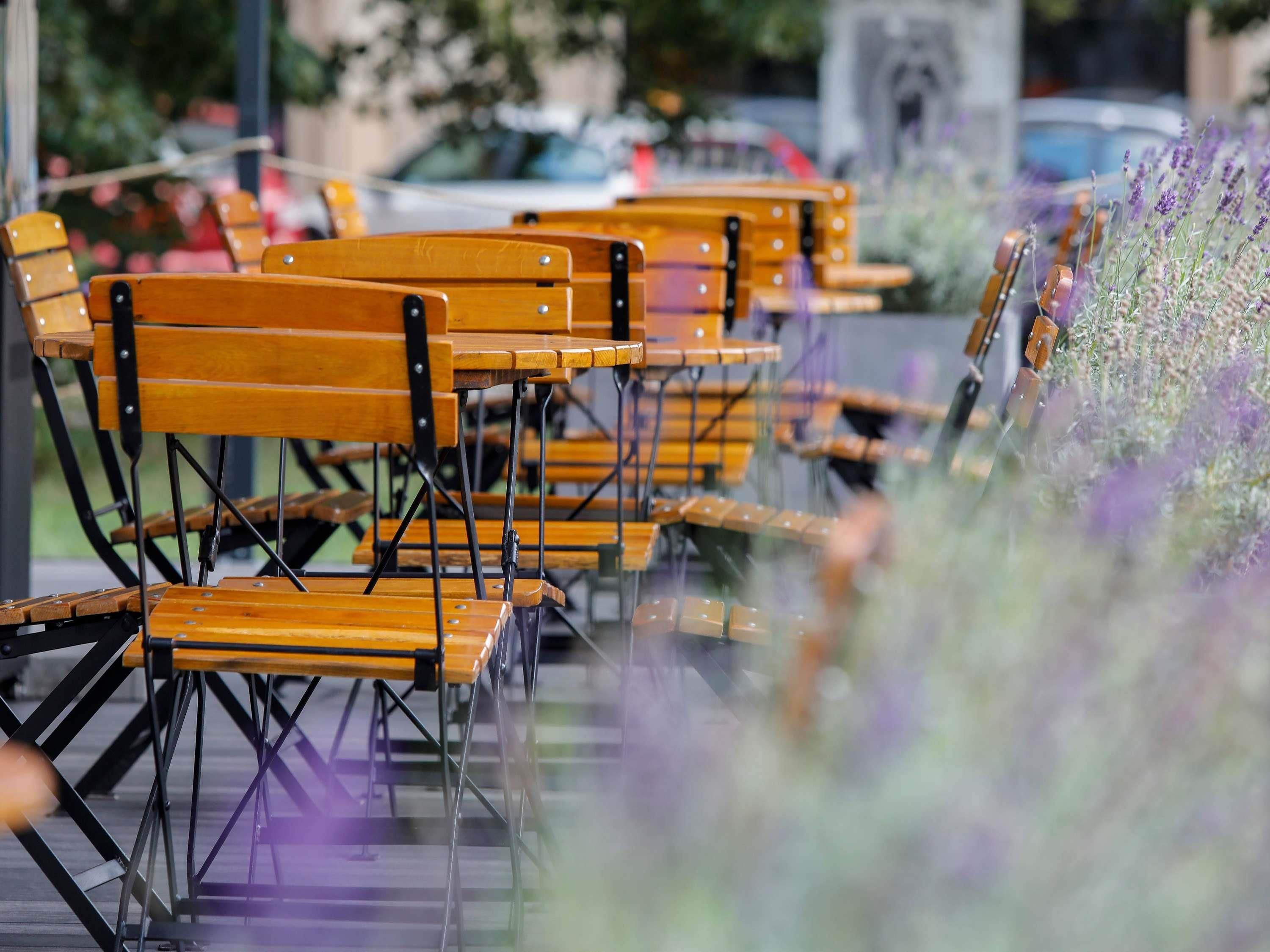 Rows of wooden chairs with metal frames, arranged outdoors.