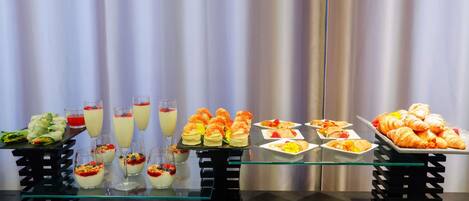 A buffet table with various food items and drinks.