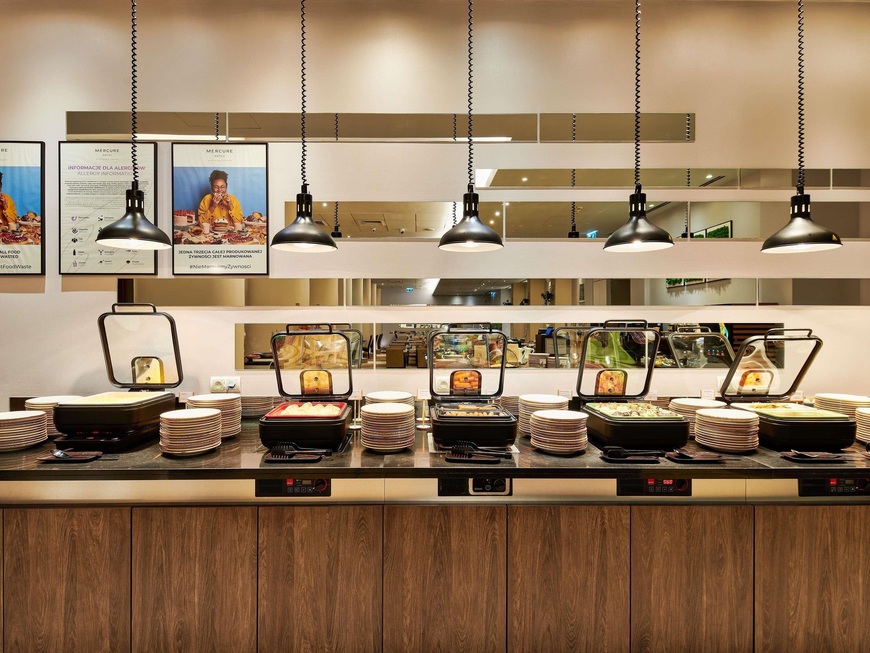 A buffet area with multiple food stations, overhead lighting, and informational posters on the wall.