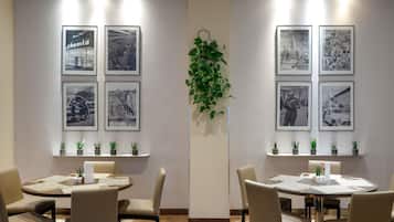 A conference room with a modern design, featuring a central plant, framed black and white photographs on the walls, and a carpeted floor.