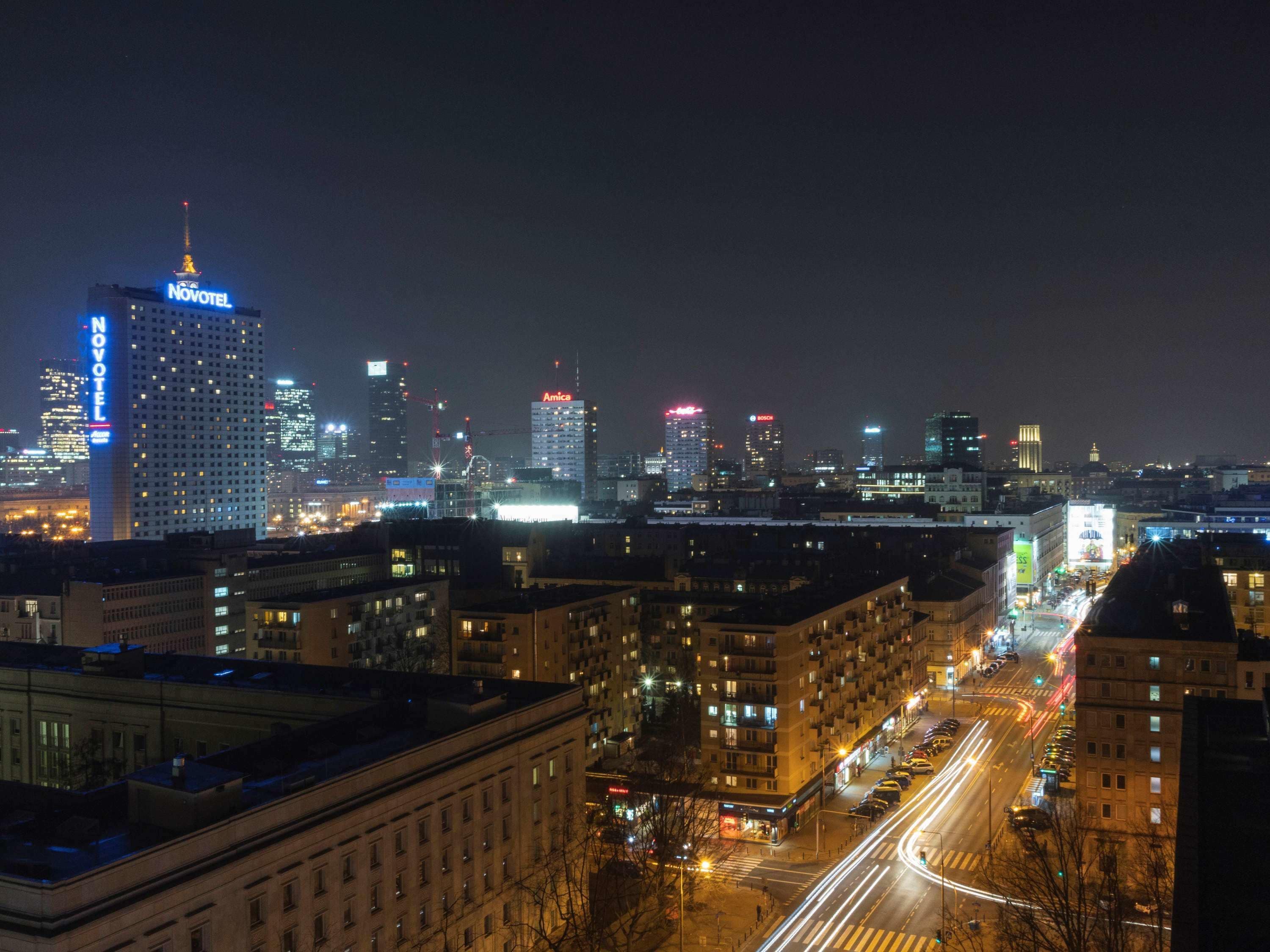 A cityscape at night with illuminated buildings, including a hotel named Novotel.