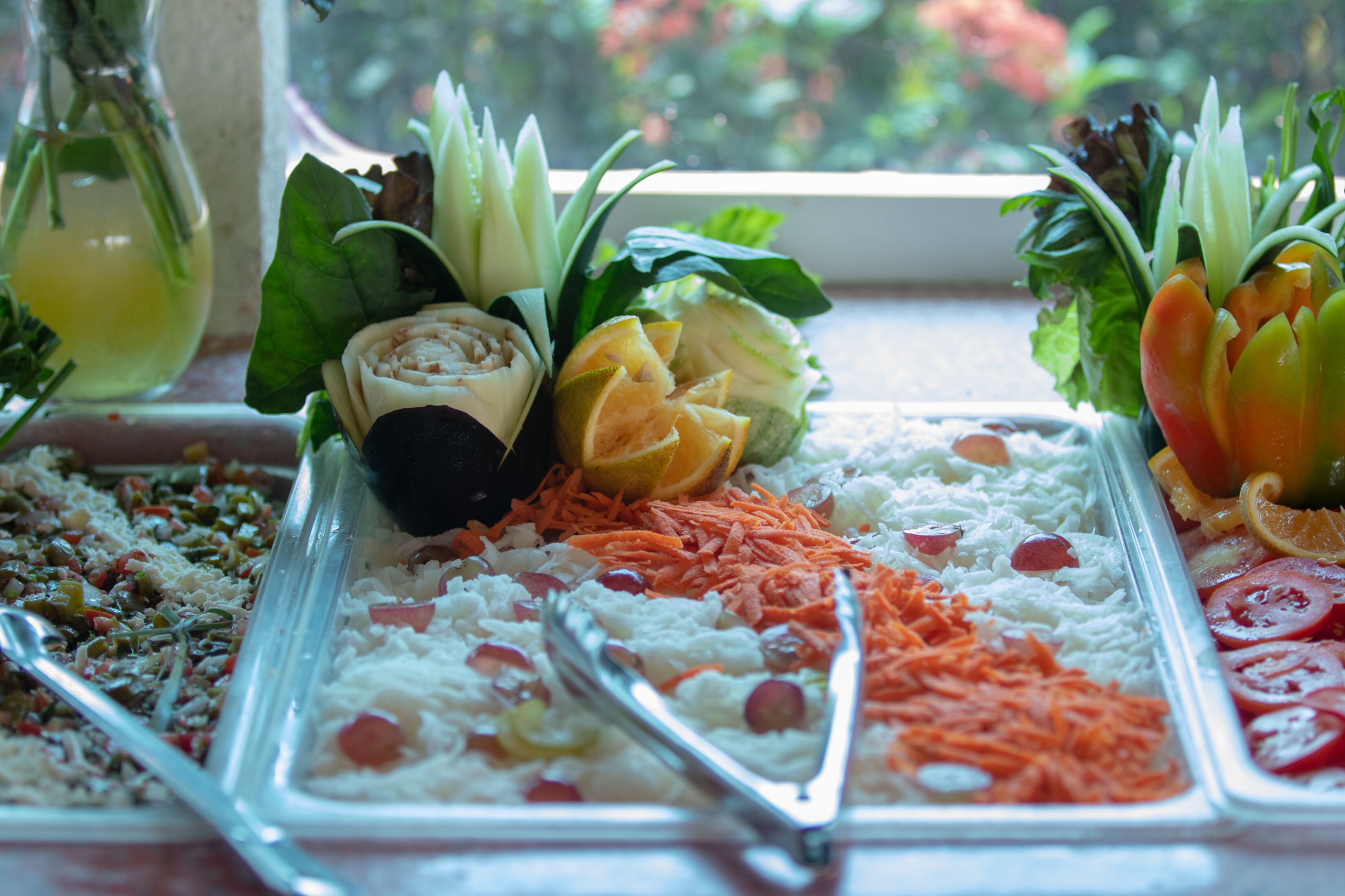 Un buffet proposant une variété de plats, notamment du riz, des légumes et des fruits.