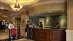 A hotel reception area with a wooden reception desk, a chandelier, and a sign indicating the hotel name. - Peermont Walmont at Graceland, Secunda (Secunda)