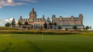 A large, historic building with a prominent clock tower, surrounded by a well-maintained golf course. - Peermont Walmont at Graceland, Secunda (Secunda)