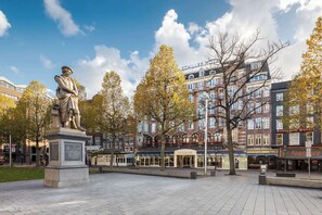 A statue in a public square with buildings in the background. - NH Amsterdam Schiller (Amsterdam)
