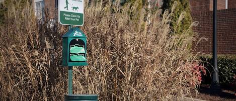A pet relief area sign and a trash bin in a residential area.
