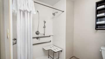 A modern bathroom with a walk-in shower, grab bars, a white toilet, and a towel rack.