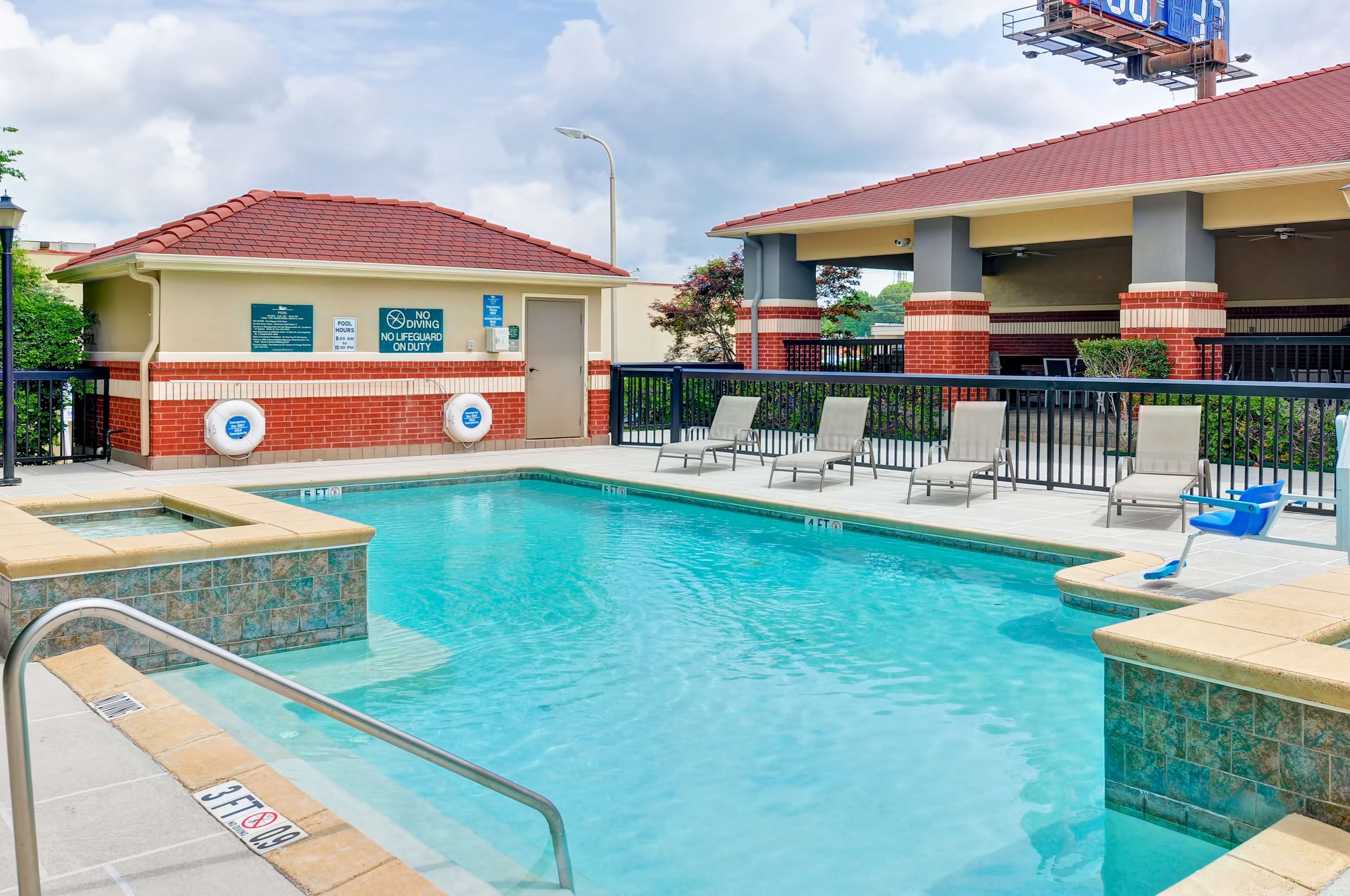 A swimming pool with lounge chairs and a lifeguard station.