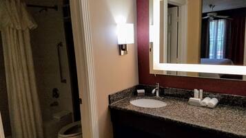 A bathroom with a sink, mirror, and toilet.