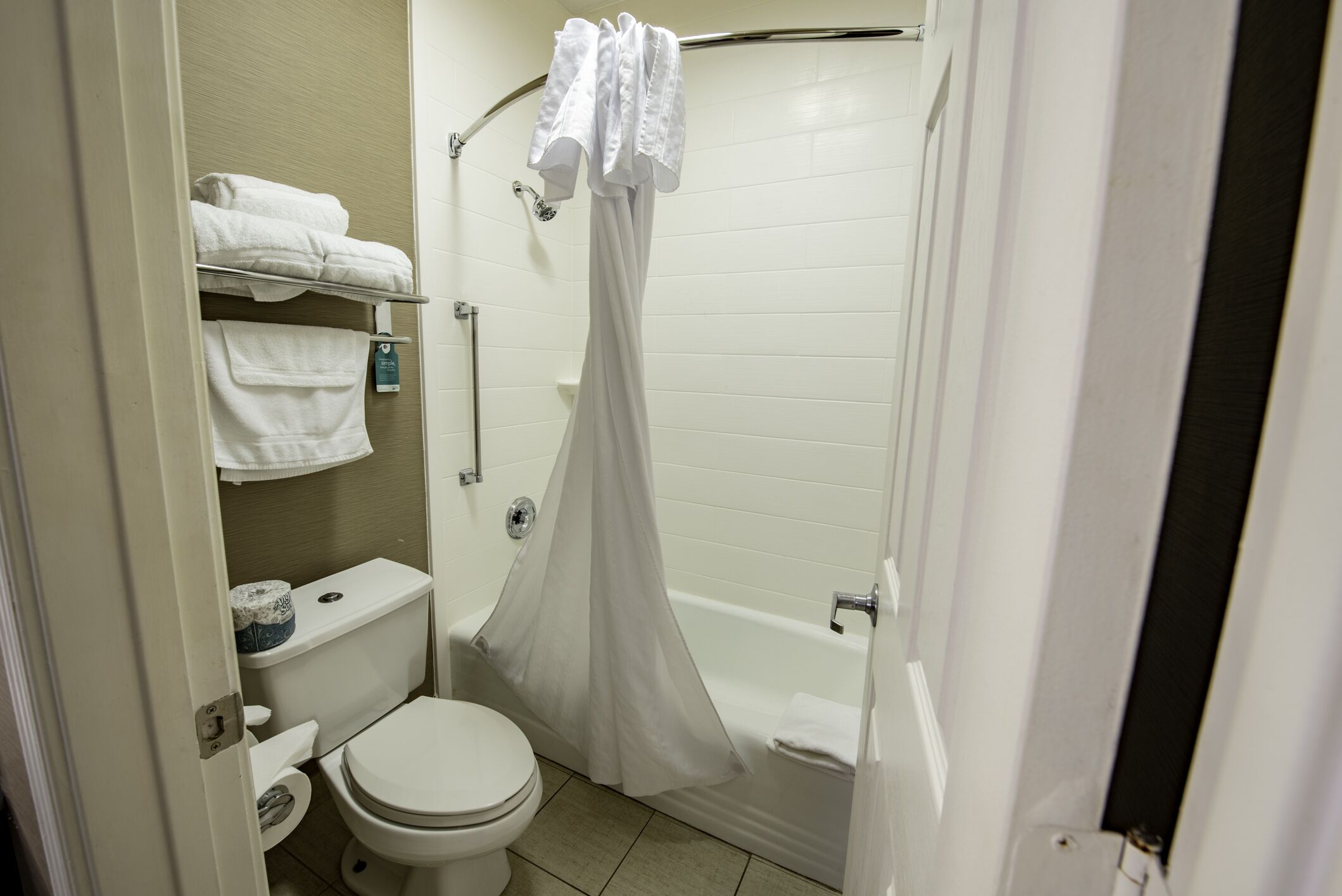 A small, clean bathroom with a toilet, sink, and shower.