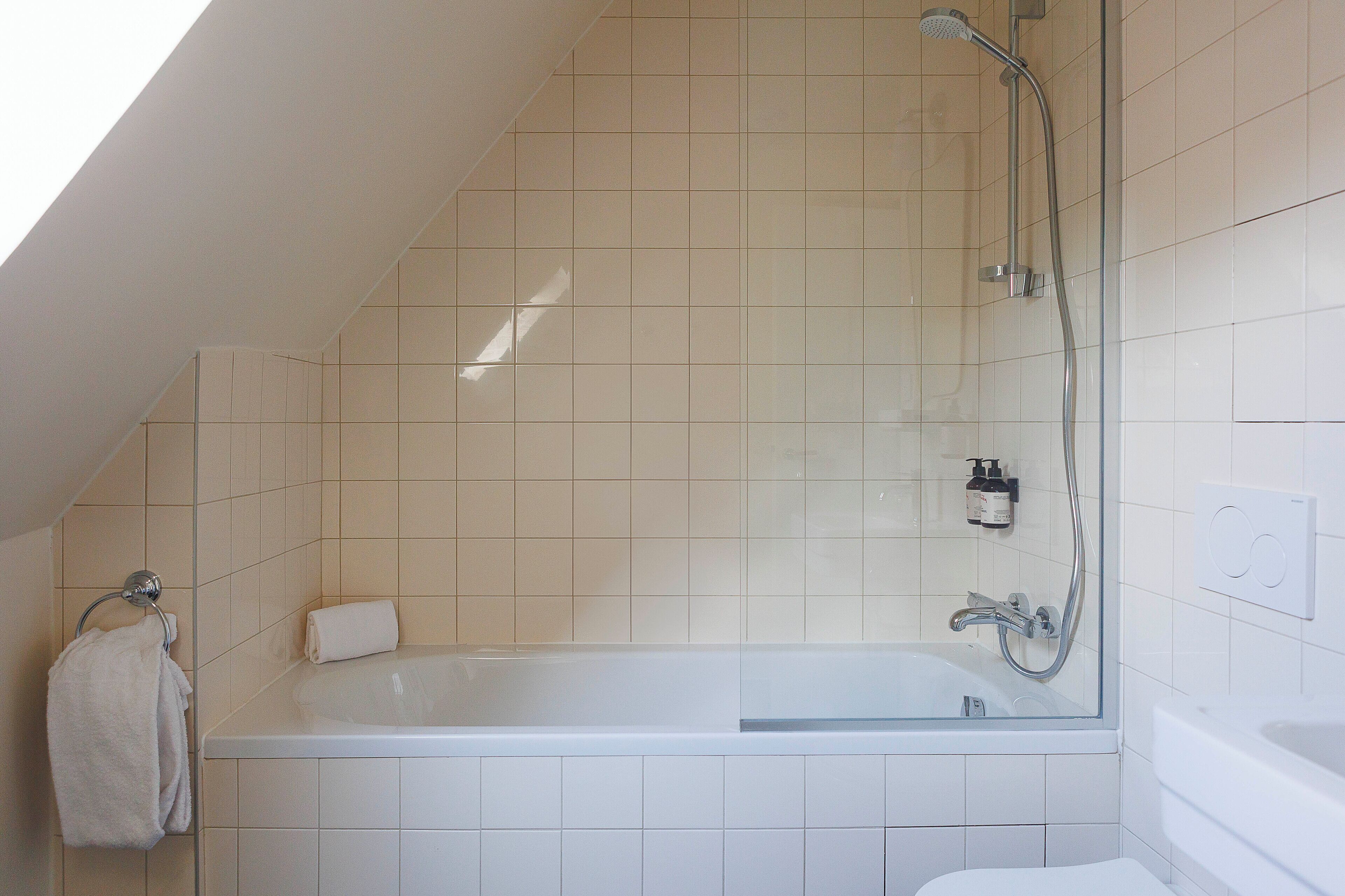 A modern bathroom with a freestanding bathtub, a glass-enclosed shower, and a toilet.