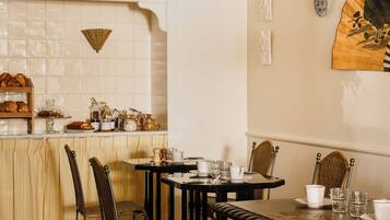 Un comedor con una mesa de madera, sillas y una encimera de cocina con alimentos.