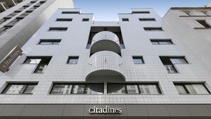A modern building with the name 'citadines' prominently displayed. It features a symmetrical facade with multiple windows and a central cylindrical structure. - Citadines Austerlitz Paris (Paris)