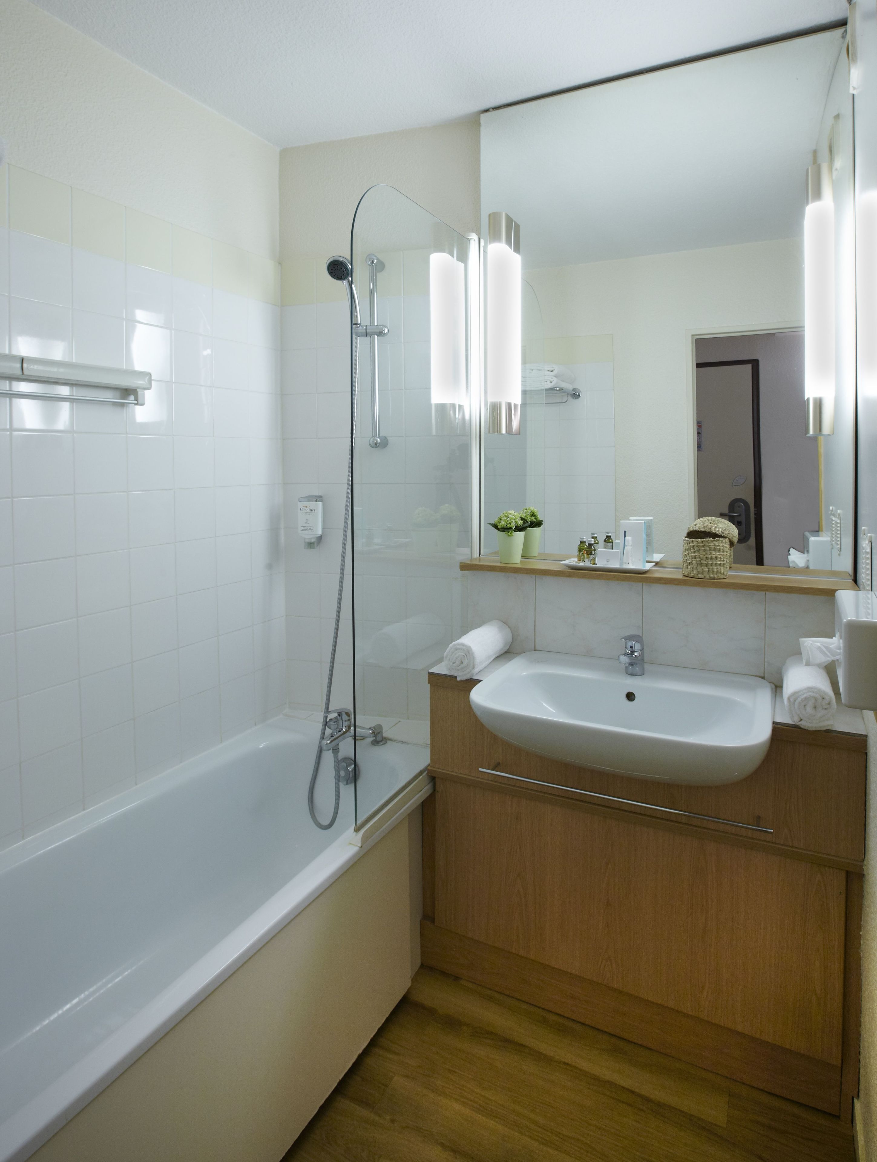 A modern bathroom with a bathtub, a shower, a sink, and a mirror.