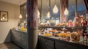 Een buffetgedeelte met diverse gerechten en een spiegel die de ruimte weerspiegelt.