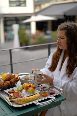 A tray with breakfast items including croissants, a banana, and a fruit bowl.